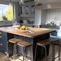 Island with timber countertop and stools with timber seats. 