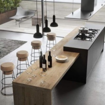 Contemporary island, with hob on work bench, and timber seating area.