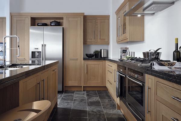 Solid timber frame with a simple shaker solid oak door inset finished in natural lacquer with Angola black granite worktops